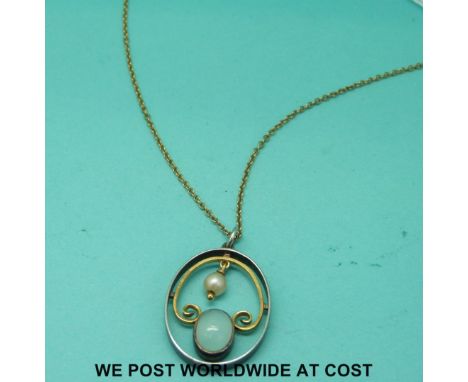 A yellow metal chain with a white and yellow metal pendant set with a moonstone and pearl 