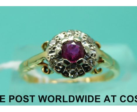 An 18ct gold ring set with a ruby surrounded by diamonds (size L)
