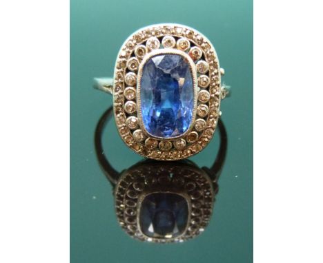 A Victorian white metal ring set with a cushion cut natural sapphire of approximately 4.2ct surrounded by diamonds 