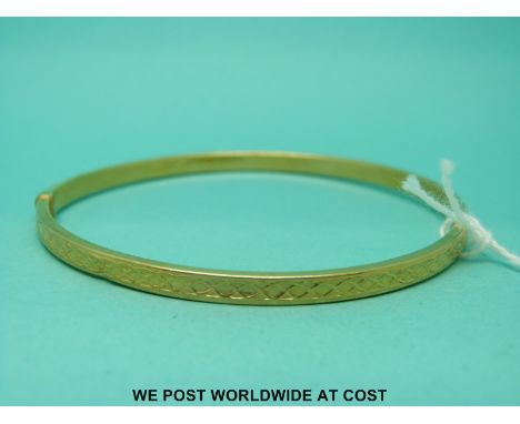 A 9ct gold bangle with cross decoration (3.8g)