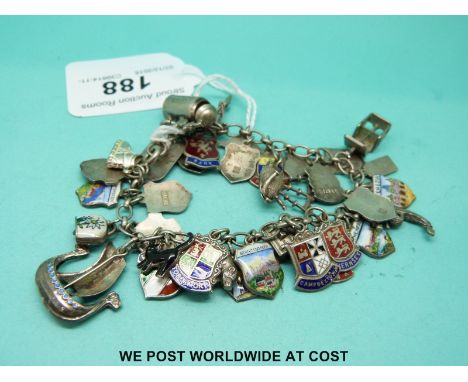 A silver charm bracelet including silver and enamel crests 