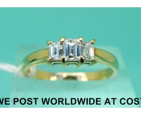 An 18ct gold ring set with three emerald cut diamonds, the centre diamond approximately 0.2ct (size N)