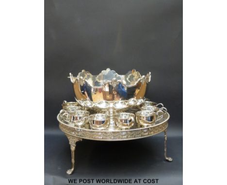 A large silver plated punch set comprising tray, bowl, ladle and 12 cups (diameter 52cm)