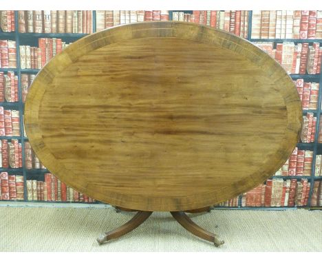 An oval mahogany tilt-top table with line inlaid and crossbanded rosewood surround raised on brass feathered feet and castors