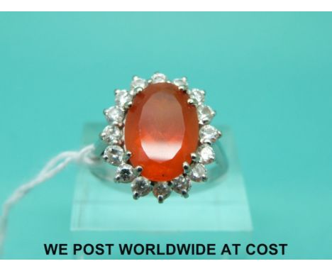 An 18ct white gold ring set with an oval cut fire opal surrounded by diamonds with original receipt (size P)