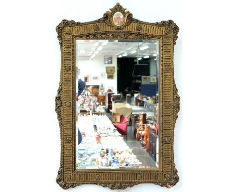 A 19TH C STYLE GILTWOOD AND COMPOSITION MIRROR WITH BEVELLED PLATE, SURMOUNTED BY A&nbsp;SEVRES&nbsp; STYLE PORCELAIN PLAQUE,