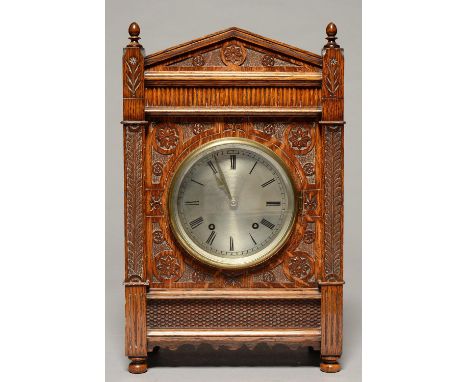 A GERMAN CARVED OAK MANTEL CLOCK, C1900, OF ARCHITECTURAL FORM, WITH TURNED FINIALS, SILVERED DIAL AND WINTERHALDER AND HOFME