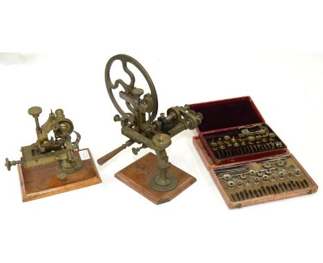 TWO VICTORIAN OR EARLY 20TH C BRASS WATCHMAKER'S TOPPING TOOLS ON WOOD BASE, 21 AND 25CM H AND TWO FRENCH SETS OF ACCESSORIES