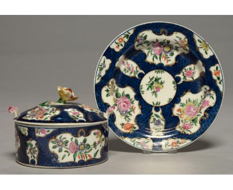 A WORCESTER SCALE BLUE GROUND BUTTER DISH, COVER AND STAND, C1770, PAINTED WITH FLORAL RESERVES, 15.7CM DIAM, UNDERGLAZE BLUE