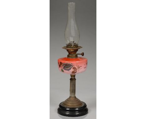 A VICTORIAN BRASS OIL LAMP WITH ENAMELLED 'PEACH BLOOM' GLASS FOUNT, ON BLACK GLAZED POTTERY FOOT, 39CM H EXCLUDING CHIMNEY, 