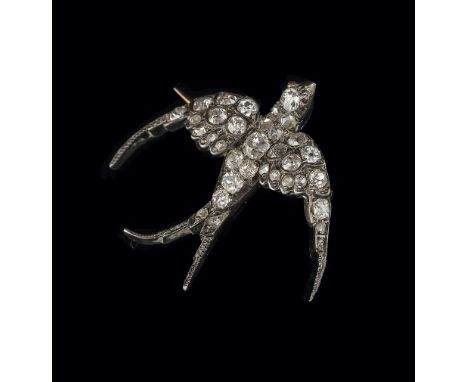 A late Victorian diamond swallow brooch, set throughout with mixed old cut and rose cut diamonds, with cabochon ruby eyes, go