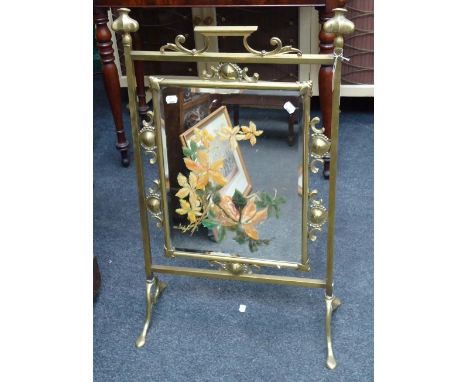 An Art Nouveau gilt brass fire screen, with inset glass panel, and floral painting, 56cm