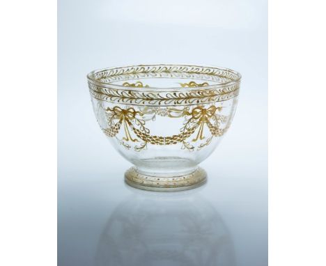 A 19th century French glass footed bowl, decorated in 'front of furnace' mustard enamel with ribbon tied swags and leafy band