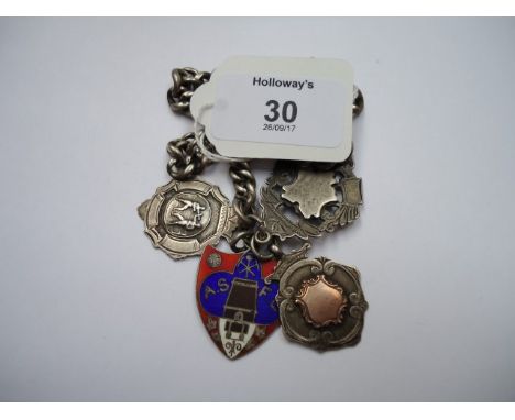 A silver curb pattern watch chain, suspending four silver and silver and enamel fobs