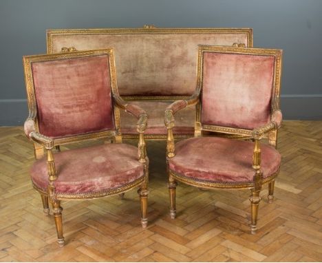 A Louis XVI style three piece carved wood and gilt gesso salon suite, with a three seat sofa and a pair of matching fauteuil 