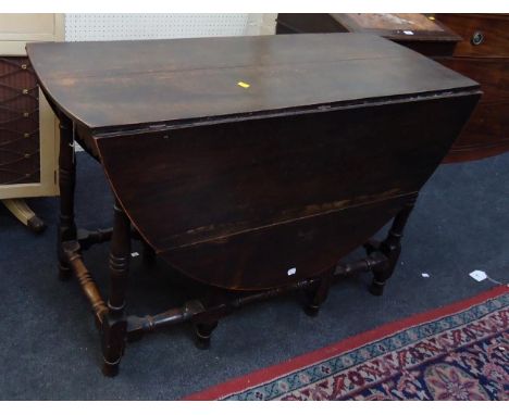 A part late 17th century/early 18th century oval oak gate leg table, with two frieze drawers, raised on a baluster and bobbin