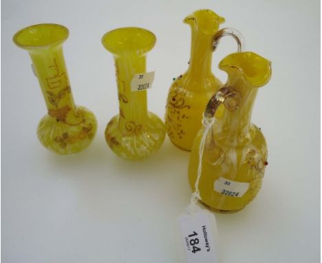 A pair of Edwardian yellow and opaque glass jugs, each having clear loop handle and enamel decorated with daisies and beaded 