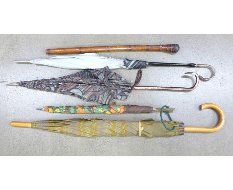 Four vintage umbrellas, three with plastic handles and a bamboo cane with oriental carving 
