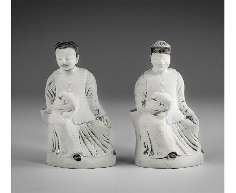 Kangxi Period, Late 17th century AD. A pair of glazed porcelain figures, one an elderly man seated and holding a pet in his r