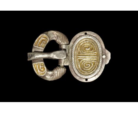 4th-5th century AD. A silver buckle with parcel-gilt detailing comprising: a flat-section loop with beast-head panels, parcel