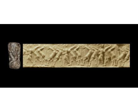 3rd millennium BC. A carved hardstone cylinder seal with intaglio design of a standing hero flanked by rampant beasts; suppli