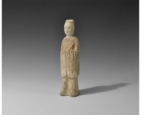 Northern Qi Dynasty, 550-577 AD. A hollow-formed ceramic figure of a standing robed male with cap and long-sleeved mantle, br