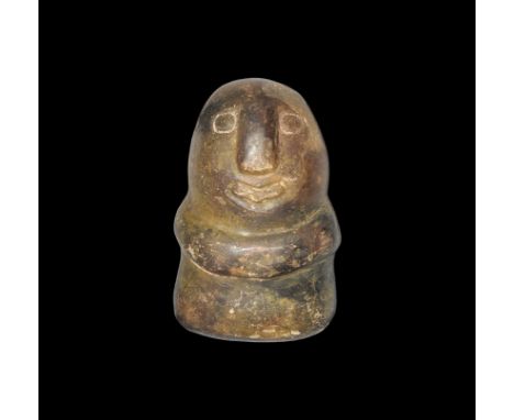 4th century BC. An oval polished stone idol with rectangular base, carved facial features and clasped hands. Property of a ge