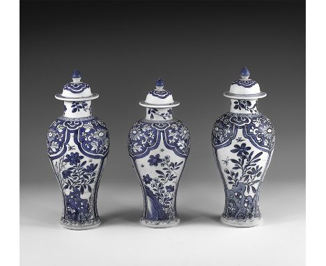 Kangxi Period, Late 17th century AD. A trio of blue and white glazed ceramic meiping vases, each with bell-shaped lid and kno