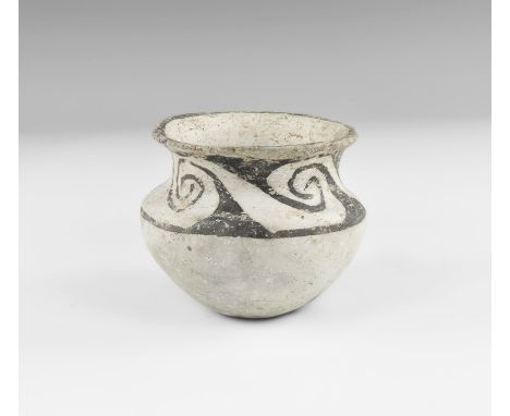 2nd millennium BC. A grey ceramic jar with broad body, dimple base, deep shoulder, everted rim; band of black painted spirals