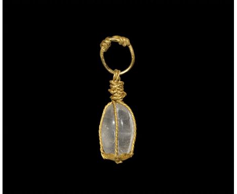 8th-11th century AD. A gold pendant with a facetted and polished quartz crystal set in a cage of twisted gold wire attached t