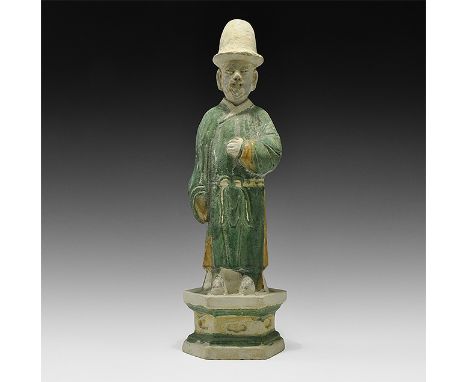 Ming Dynasty, 1368-1644 AD. A large hollow-formed green-glazed ceramic figurine on a hexagonal pedestal base in loose robe, t