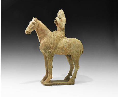 Tang Dynasty, 618-906 AD, or later. A provincial ceramic figurine of horse and rider on a rectangular base; the horse standin