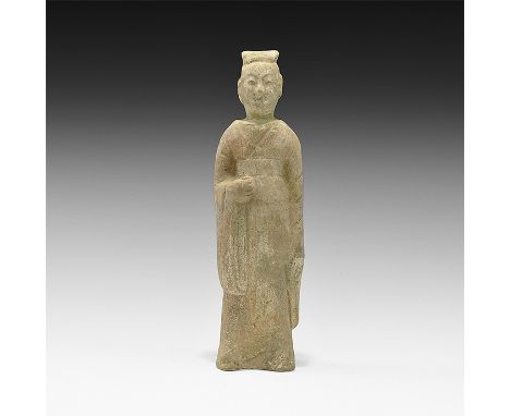 Northern Qi Dynasty, 550-577 AD. A hollow-formed ceramic figure of a standing robed male with cap and long-sleeved robe, one 