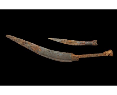 2nd century BC-2nd century AD. A group of two iron single-edged daggers comprising: the larger with swept curve to the blade 