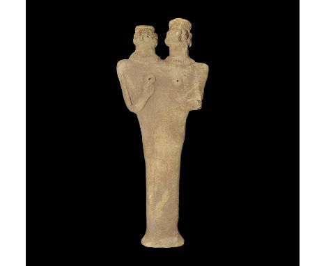 12th-8th century BC. A flat-backed ceramic figurine depicting a figure with two heads; the eyes and breasts formed with round