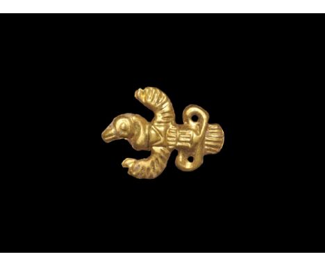 6th century BC. A repousse foil appliqué in the form of a bird with spread wings, pierced extensions to the tail, six attachm