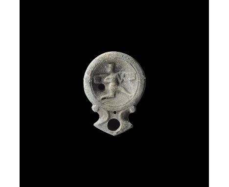 1st century AD. A squat terracotta oil lamp with broad nozzle, scrolled shoulders, high-relief image of a running figure look