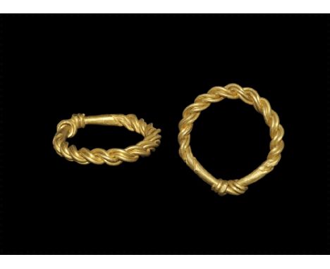 9th-11th century AD. A substantial round-section gold hoop with the ends coiled about the shank in a 'clasped hands' configur
