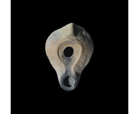 3rd-4th century AD. A terracotta oil lamp with lug handle to the rear, broad chamfered shoulders, discus with outer band, squ
