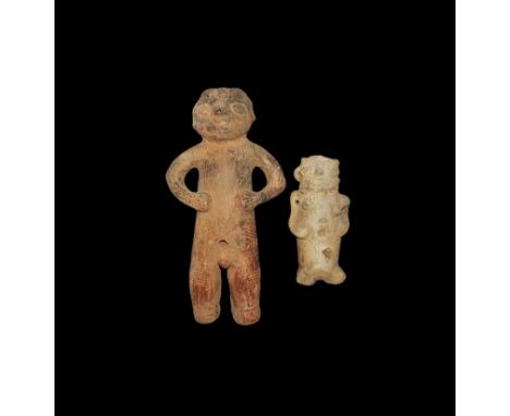 1st-8th century AD. A pair of ceramic figures comprising: a large male with hands on his waist, hole to the navel and slits t