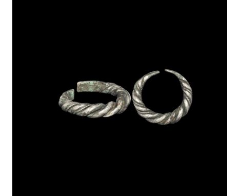 9th-11th century AD. A tapering penannular silver shank formed from two rods wound longitudinally, with twisted filigree to t