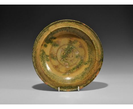 11th-12th century AD. A broad bowl with flared foot, raised rim and carination to the flange; green-ochre glaze with sgraffia