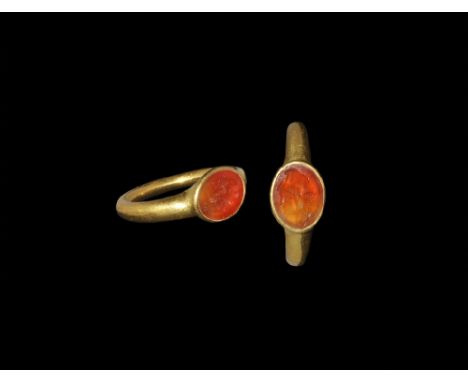 1st-2nd century AD. A round-section gold hoop with integral elliptical cell, inset carnelian cloison with intaglio profile ja