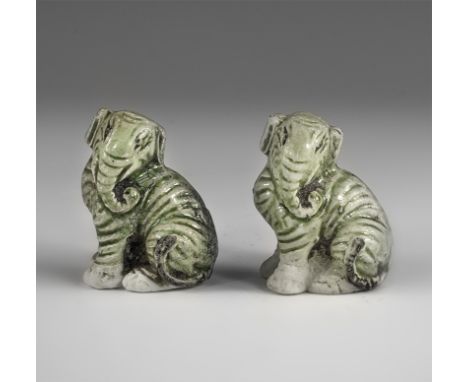 Kangxi Period, Late 17th century AD. A pair of green-glazed ceramic figurines of crouching elephants, each with the head turn