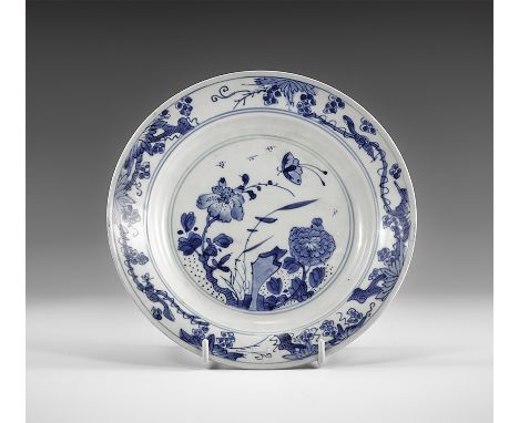 Kangxi Period, Late 17th century AD. A blue and white glazed ceramic dish with flowers and a butterfly, blossom to the border