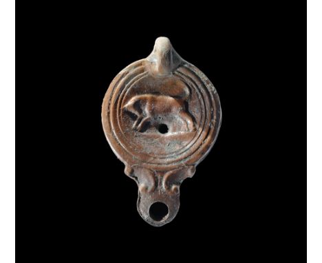 Later 1st-early 2nd century AD. A squat terracotta oil lamp with loop handle to the rear, short nozzle with scrolled shoulder