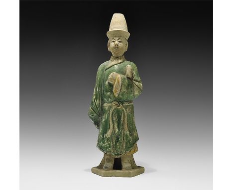 Ming Dynasty, 1368-1644 AD. A large hollow-formed green-glazed ceramic figurine on a hexagonal base in loose robe, holding a 