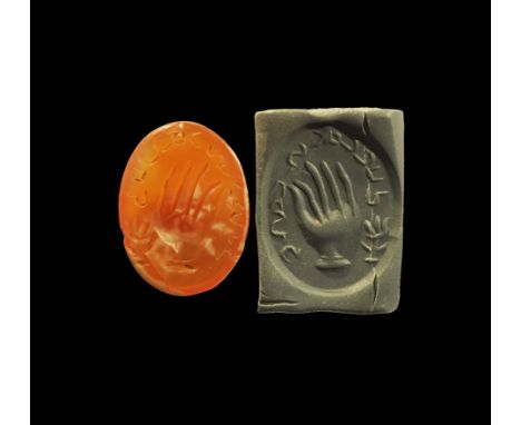 4th-6th century AD. A discoid plano-convex carnelian seal matrix with intaglio hand and legend to the outer edge; supplied wi