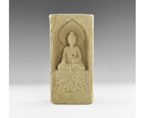 Northern Wei Dynasty, 386-534 AD. A terracotta brick carved with the image of the seated nimbate Buddha in a pointed niche wi