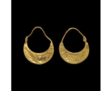 3rd century BC. A matched pair of gold earrings, each a crescentic plaque with hatched texture, beaded wire borders, granules